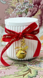 White handmade scented candle with bell and velvet ribbon